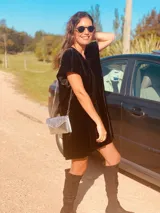 Vestido corto negro de terciopelo con bordado de flores blancas en la espalda, escote en V y corte holgado.