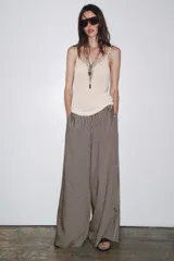 Pantalón de tiro medio con cintura elástica y bolsillos laterales ocultos en costura. Pierna ancha y diseño a rayas verticales azules y blancas.
