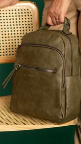 Mochila color caramelo de símil cuero, con dos bolsillos frontales con cierre y bolsillos laterales abiertos. Interior forrado con dos bolsillos con cierre y uno abierto. Tiene asa de mano y correas regulables.
