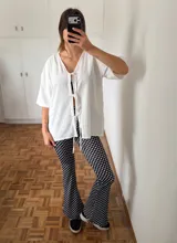 Calza larga de lycra negra con lunares blancos.