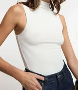 Blusa sin mangas en viscosa color blanco, con cuello alto y textura acanalada.