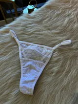 Microtanga blanca de encaje con tiras finas ajustables.