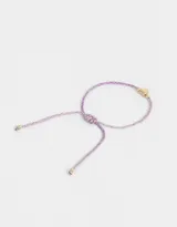 Pulsera de cordón ajustable color lila con dije de corazón dorado.