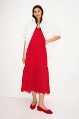 Vestido midi rojo con breteles finos, escote en V y broderie calada. Tiene corte holgado, pinzas en el busto, elástico en la espalda, fruncido escalonado y bajo festoneado. Está forrado.