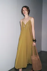 Vestido midi color ocre de Zara Woman Collection, confeccionado en hilatura con mezcla de algodón. Presenta escote pico, tirantes finos y tejido con volumen.