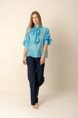 Camisa celeste con lunares marrones, cuello con lazo y mangas 3/4 abullonadas.