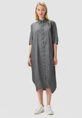 Túnica camisera midi a rayas verticales en blanco y negro, de corte holgado, con cuello camisero y abotonadura frontal.