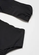Traje de baño enterizo negro asimétrico, con un solo tirante fino, abertura lateral y foam extraíble.
