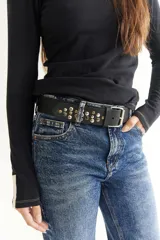 Cinto de cuero color marrón con hebilla metálica y tachas plateadas.