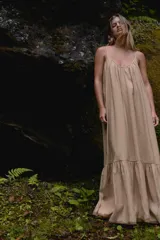 Vestido midi color beige de tejido fluido con escote pico, tirantes finos ajustables y bajo acabado en paneles con pliegues.