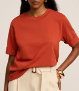 Remera de malla color blanco, de corte recto y mangas cortas con dobladillo.