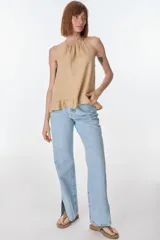 Musculosa color beige de lino, con cuello halter con volados y volados en el ruedo.