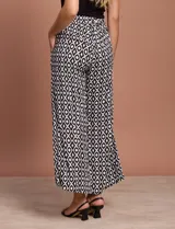 Pantalón capri estampado con flores en tonos celeste, blanco y negro. Tiene pretina elastizada en la parte trasera y bolsillos delanteros.