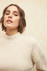 Polera de punto con cuello alto y detalle de dobladillo en las mangas, confeccionada parcialmente en lana.