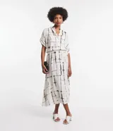 Vestido midi de viscosa color blanco con estampado de bloques negros, corte evasé, mangas cortas, cuello camisero, lazo en la cintura y cierre frontal con botones.
