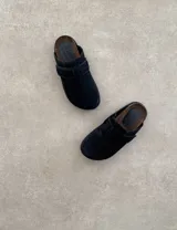 Suecos marrones de gamuza con hebilla lateral ajustable y suela de goma negra.