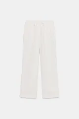 Pantalón blanco de corte recto, tiro medio, con bolsillos delanteros y traseros. Cintura elástica ajustable con cordones.