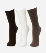 Kit de tres pares de medias largas caneladas de algodón, poliamida y elastano. Incluye un par marrón oscuro, un par blanco y un par marrón claro.