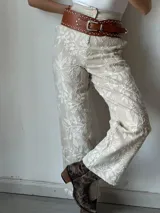 Pantalón de vestir color crudo con bordado floral blanco.