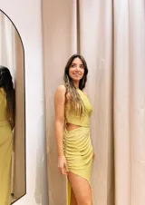 Vestido largo color dorado de lurex, con un hombro descubierto, corte en la cintura y falda con frunces y abertura lateral.