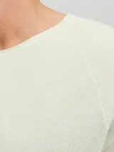 Sweater de punto color crudo, con cuello redondo y mangas largas.