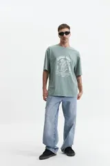 Remera verde con estampa frontal de un tigre y texto "Jungle Army". Corte oversize, mangas cortas y cuello redondo.