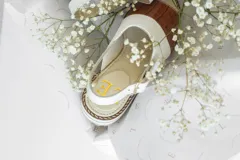 Sandalias de cuero con plataforma, color marrón con detalle de estampado tipo piel de cocodrilo en la parte delantera y blanco en la parte trasera.