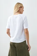 Remera color verde pistacho, de corte recto y manga corta raglán con detalle de vainillas en los hombros.