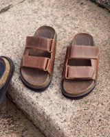 Sandalias bajas de cuero color marrón con doble tira ancha en el empeine.