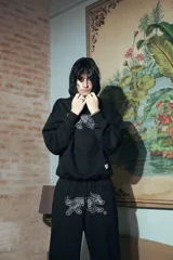 Pantalón negro de felpa de algodón, corte oversize, con doble cintura simulando bóxer y estampa de alta calidad.