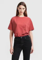 Remera de manga corta color ladrillo, corte holgado, con cuello redondo y bolsillo en el pecho.