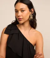 Vestido corto blanco de chiffon con un solo hombro y volados superpuestos.