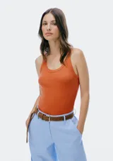 Musculosa slim color ocre, de tela acanalada con cuello redondo y sisas anchas.