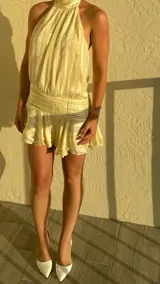 Vestido corto celeste con finas rayas verticales blancas, cuello halter fruncido y cintura y ruedo con frunces.