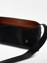 Bolso de hombro negro de poliéster y poliuretano, con correa regulable con hebilla metálica, cierre de solapa y logo grabado.