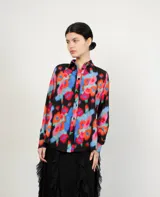 Camisa blanca de corte amplio con cuello clásico y botones negros.