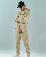 Pantalón de jogging color beige, con dos bolsillos laterales amplios, un bolsillo trasero y cordón personalizado, diseñado con el texto 'Quality Matters' en la pierna.