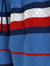 Short de baño Tommy Hilfiger con estampado de rayas horizontales en azul, blanco y rojo. Diseño con monograma TH estampado en azul sobre las rayas azules. Cintura elástica con cordón ajustable.