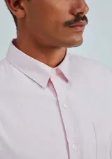 Camisa de vestir azul marino, de corte clásico, con cuello abotonado, manga larga y bolsillo en el pecho.