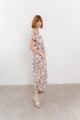 Vestido largo de algodón con elastano, estampado con manchas tipo vaca en tonos marrón y blanco. Tiene cuello redondo con ribete en contraste.
