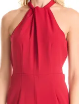Enterito largo de crepe color rojo, con escote halter anudado y pierna ancha. Presenta bolsillos delanteros y abertura en la espalda con cierre invisible y botón.