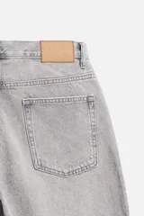 Pantalón de jean gris de corte recto, con cinco bolsillos, efecto lavado y cierre frontal con botones.