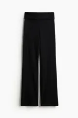 Pantalón negro de punto suave, con cintura ancha plegable y corte acampanado.