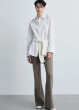 Pantalón largo acampanado color marrón topo, de tejido de punto con cintura elástica y tiro medio.