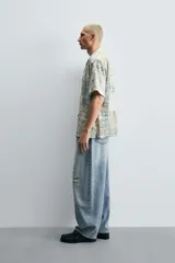 Pantalón de jean celeste con lavado gastado, corte holgado y roturas en ambas piernas.