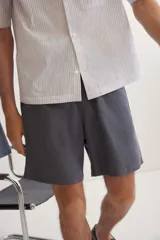 Short gris oscuro de lino y algodón, corte relaxed fit, con cintura elastizada ajustable con cordón, bolsillos laterales y bolsillo trasero.