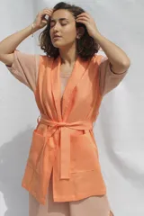 Chaleco color durazno de lino, con solapas, bolsillos delanteros y lazo para atar en la cintura.