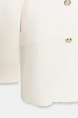 Blazer cruzada de color negro, confeccionada en tejido con lino. Presenta cuello solapa con muescas, hombreras, manga larga, falsos bolsillos con solapa y cierre frontal cruzado con botones metálicos dorados.