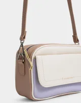 Bandolera rectangular de cuerina texturada en color crema, lila y beige. Tiene correa regulable desmontable, bolsillo frontal con solapa y broche con botón, y acceso mediante cierre superior.