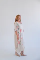 Vestido largo color beige con estampado de flores color salmón, corte amplio y mangas 3/4 con botón.